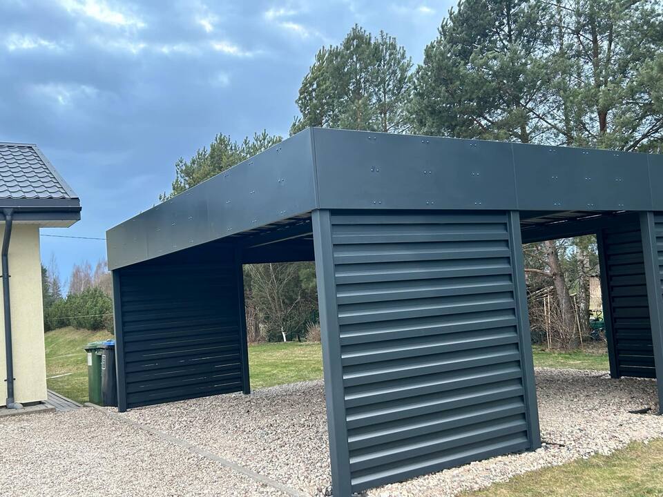 Carport i mørkt stål med spilevegg på siden