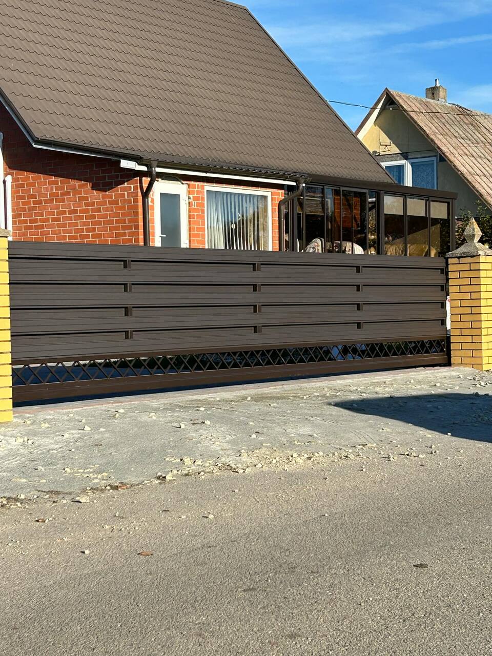Gjerde med horisontale mørke spiler langs boliggate