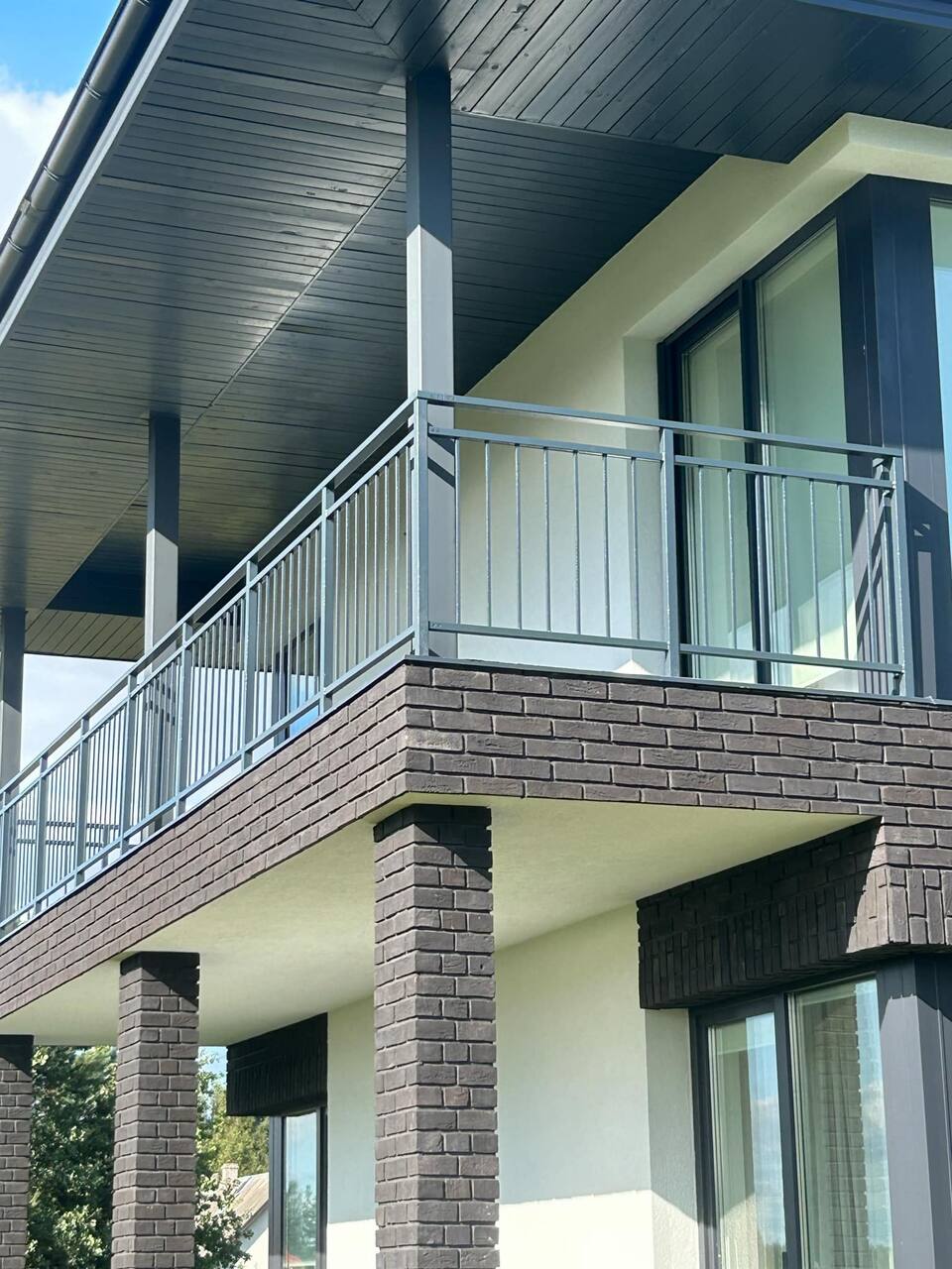 Balkongrekkverk med horisontale stålprofiler på moderne bolig